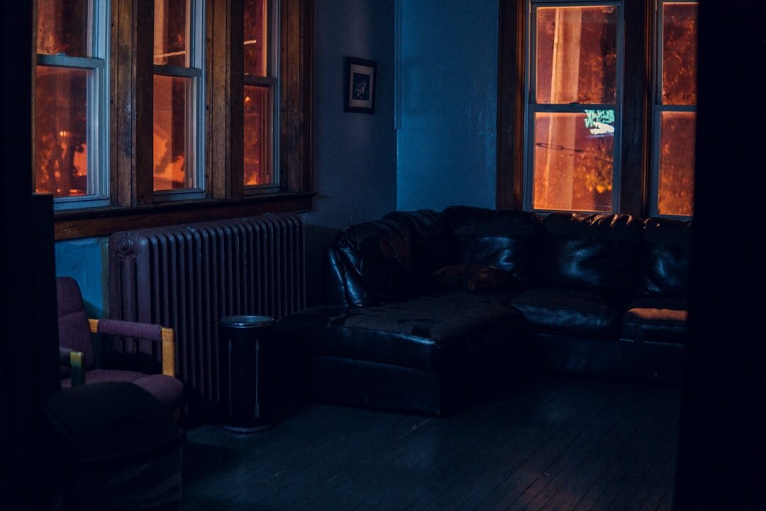 Moody dramatic interior with a leather armchair and warm lamp light at night